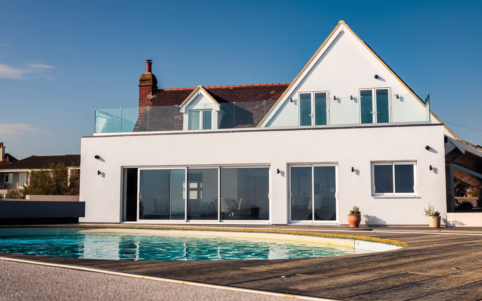 Newly renovated exterior of Selsey Beach House with first-floor glass terrace and heated swimming pool