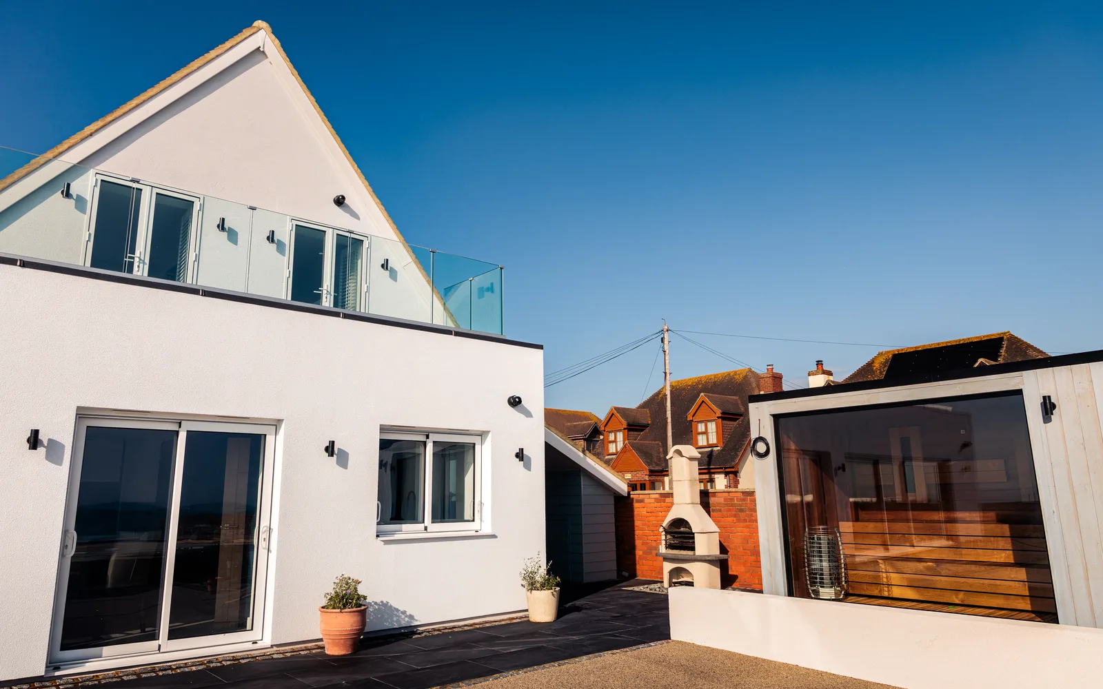 Wellness One outdoor sauna with panoramic glass window in the garden at Selsey Beach House, beside the new extension and terrace